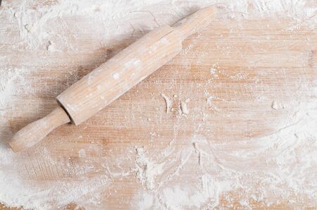 Rolling pin on a wooden tray covered with flourの写真素材