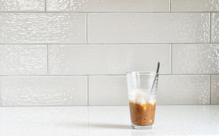 Vietnamese iced coffee with condensed milk, cafe sua da on granite counter top against a ceramic backsplashの写真素材