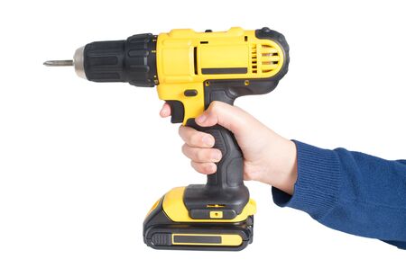 Hand from young kid handling a yellow power drill isolated on white backgroundの写真素材