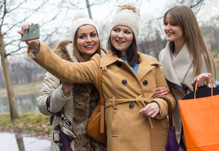three adult beautiful shopping girls photographed with a mobile phone
