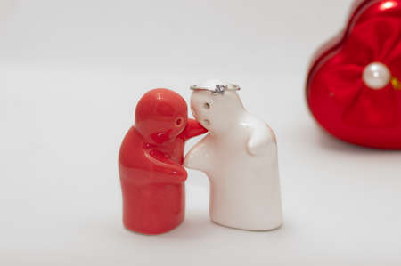 Ceramic doll red and white wedding ring overhead feeling hug  in white background.の写真素材