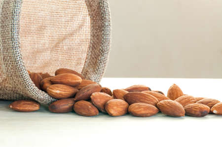almonds in sack on wood table backgroundの写真素材