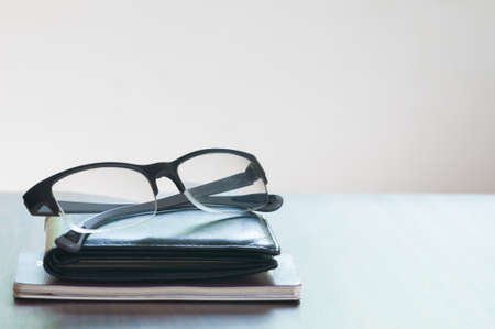 The glasses and wallet and passport isolated on the wooded tableの写真素材