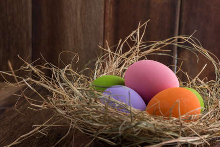 Easter eggs in nest on old wooden backgroundの写真素材