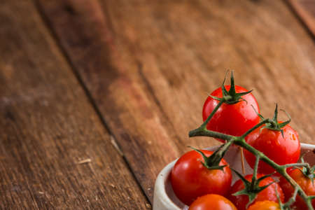 Fresh cherry tomatoes on old wooden backgroundの写真素材