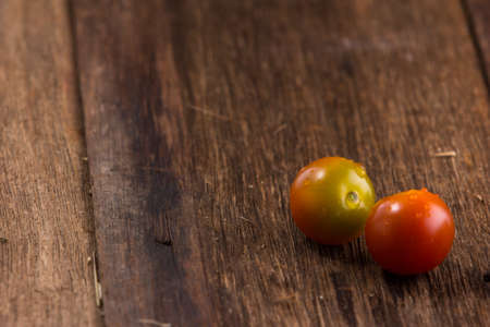 Fresh cherry tomatoes on old wooden backgroundの写真素材