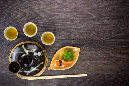 tea set and sushi on old wood backgroundの写真素材