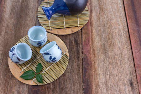 Japanese Sake drinking set on old wood texture backgroundの写真素材