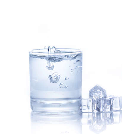 Water is poured into a glass with ice cubes