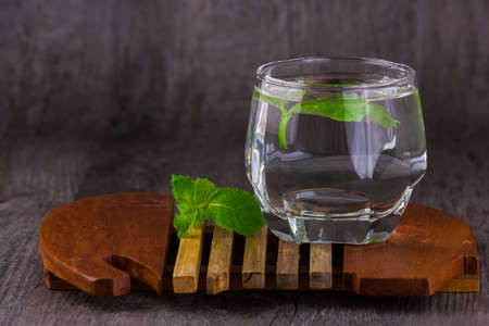 water in glass old wood backgroundの写真素材