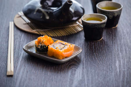 tea set and sushi on old wood backgroundの写真素材