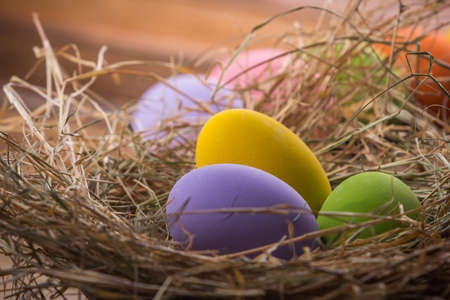 Easter eggs in nest on old wooden backgroundの写真素材