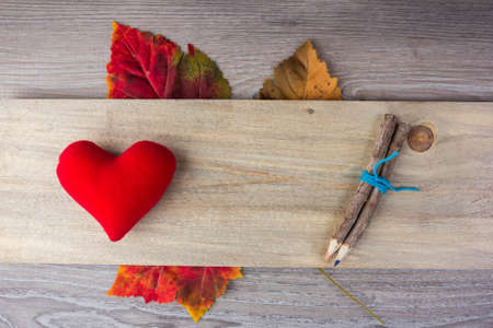 Heart shaped pillows and pencil on wood.の写真素材