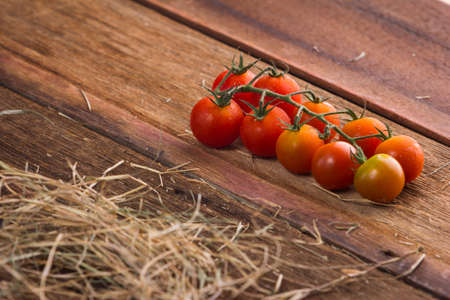 Fresh cherry tomatoes on old wooden backgroundの写真素材