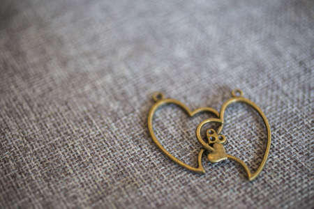 Heart pendant on old fabric, texture background, valentine conceptの写真素材