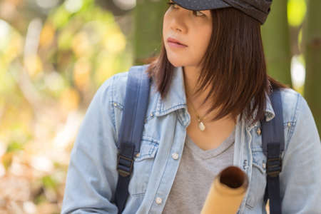 Woman with backpack holding a map in the countryside