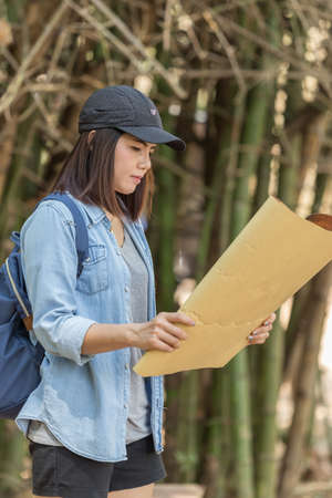 Woman with backpack holding a map in the countrysideの写真素材