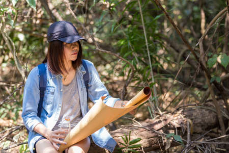 Woman with backpack holding a map in the countryside