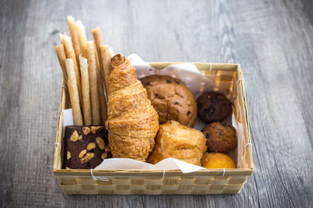bread and rolls on old wood background (bread, bakery, basket)の写真素材