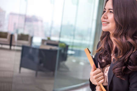 Beautiful Asia business woman over blue office background.の写真素材