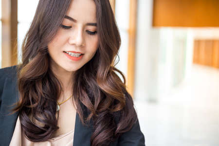 Beautiful Asia business woman over blue office background.の写真素材
