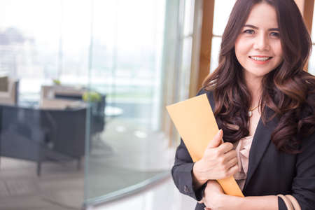 Beautiful Asia business woman over blue office background.の写真素材