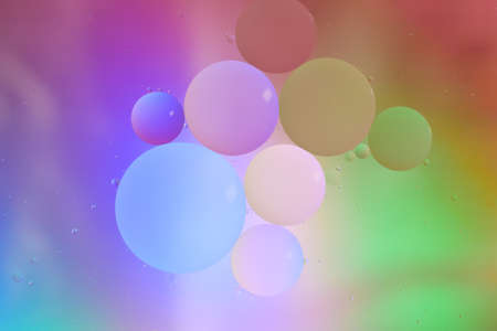 Top view movement of oil bubbles in the liquid. Oil surface multicolored background. Fantastic...