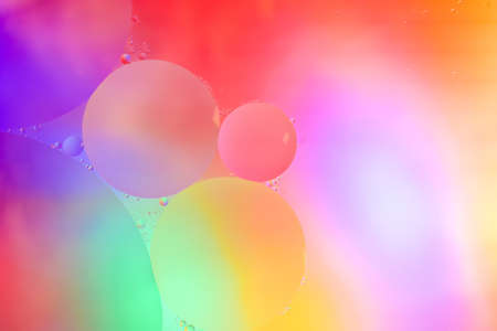 Top view movement of oil bubbles in the liquid. Oil surface multicolored background. Fantastic...