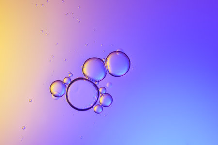 Top view movement of oil bubbles in the liquid. Oil surface multicolored background. Fantastic...