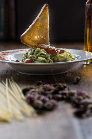 Spaghetti with pesto sauce and parmesan cheese, selective focus