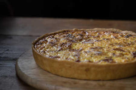 French onion tart on a wooden table in a rustic style.