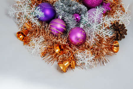 Christmas decoration of tinsel, Christmas balls, snowflakes, beads and bells and a wooden shaped candles.の写真素材