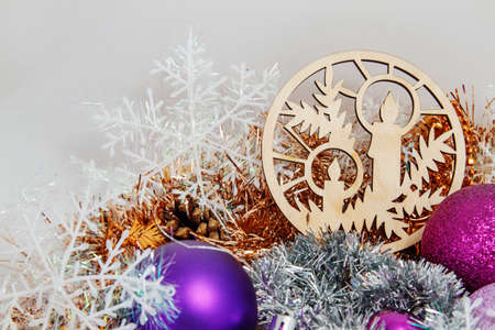 Christmas decoration of tinsel, Christmas balls, snowflakes, beads and bells and a wooden shaped candles.の写真素材