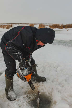 Man cutting chainsaw shell in iceの写真素材