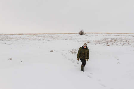 Male Traveler walking in the winter steppeの写真素材