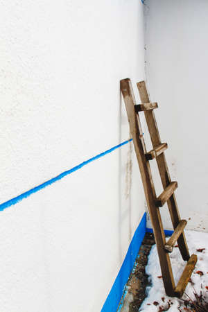 white wall village house with wooden staircase backgroundの写真素材