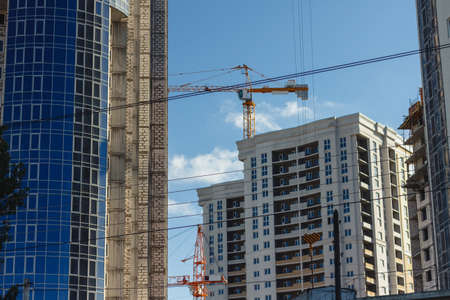 Inside place for many tall buildings under construction and cranes under a blue sky