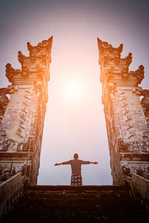 Man is standing in the gate of Lempuyang temple on Bali isalnd, Indonesiaの写真素材