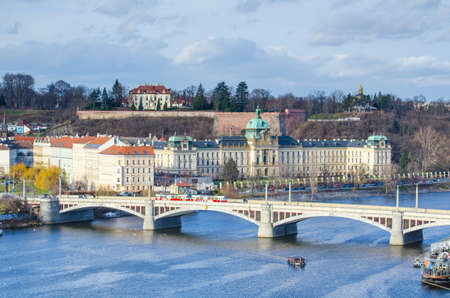 view of the manes bridge with a building of the czech parliament behind it.のeditorial素材