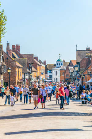 STRATFORD UPON AVON, UNITED KINGDOM, APRIL 8, 2017: People are strolling alongside traditional brick houses on Henley street in Stratford upon Avon, Englandのeditorial素材