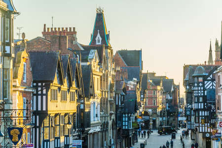 CHESTER, UNITED KINGDOM, APRIL 7, 2017: Traditional tudor houses alongside the Eastgate street in the central Chester during sunset, Englandのeditorial素材