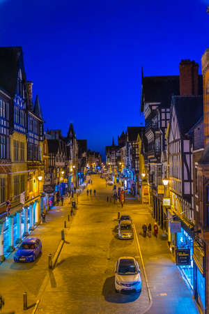 CHESTER, UNITED KINGDOM, APRIL 7, 2017: Sunset view of traditional tudor houses alongside the Eastgate street in the central Chester, Englandのeditorial素材