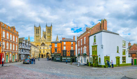 LINCOLN, UNITED KINGDOM, APRIL 10, 2017: People are walking on a square in front of the Lincoln cathedral, Englandのeditorial素材