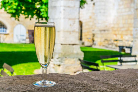 Glass with wine situated inside of the Les Cordeliers cloister in Saint Emilion, Franceの写真素材