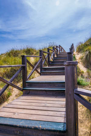 A wooden bridge over sand dunes at Cala Mesquida, Mallorca, Spainの写真素材