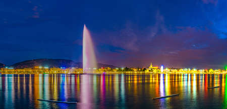 Sunset view of Geneva dominated by Jet d'eau fountain and Saint Pierre Cathedral, Switzerlandの写真素材
