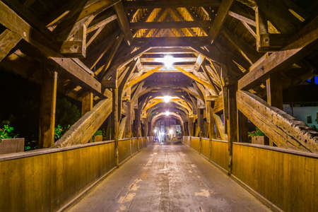 Night view of Pont de Berne, a beautiful wooden bridge over river Sarine in Fribourg, Switzerland