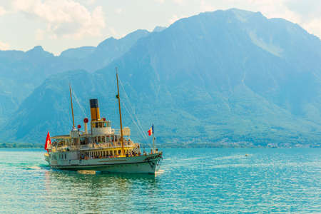 Passenger ferry is arriving to the pier at port at Vevey, Switzerlandの写真素材
