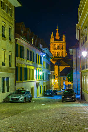Night view of cathedral of our lady at the end of a narrow street in the old town of Lausanne,...