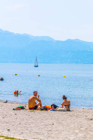 LAUSANNE, SWITZERLAND, JULY 19, 2017: Locals are enjoying a sunny day on a beach at Geneva lake near Lausanne, Switzerlandのeditorial素材